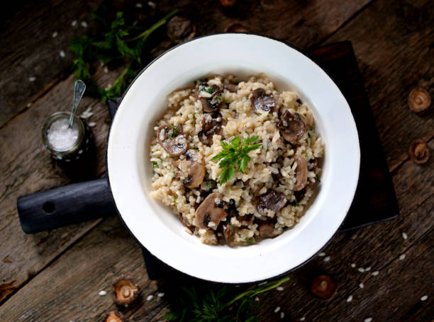 istock Risotto with mushrooms on an old wooden background. Rustic style. 681305244