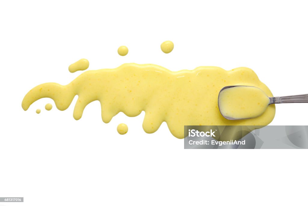 splashes and spilled Caesar dressing with a spoon isolated on white background. flat lay, top view Yellow Stock Photo