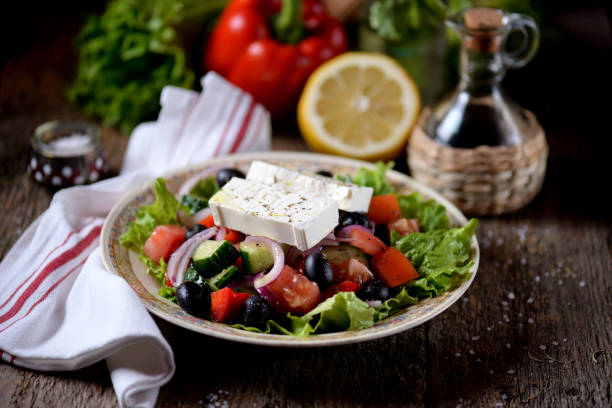 Classic Greek salad from tomatoes, cucumbers, red pepper, onion with olives, oregano and feta cheese. stock photo