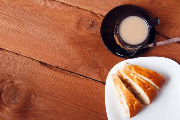 istock Fresh homemade apple pie and tea with milk on a wooden background 681368430