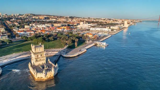 Aerial panorama of Belem Tower and Belem district at sunset.Tower of St Vincent on the bank of the Tagus River with discovery monument and 25 April bridge.Lisbon,Portugal.Amazing destinations