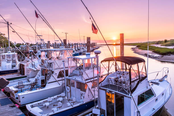 barcos de pesca descansando con cálido crepúsculo de verano en cape cod - orleans fotografías e imágenes de stock