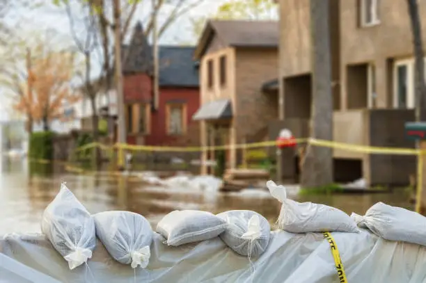 Photo of Flood Protection Sandbags with flooded homes in the background