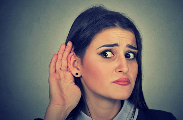 donna con gesto mano a orecchio che ascolta attentamente - indiscreet foto e immagini stock