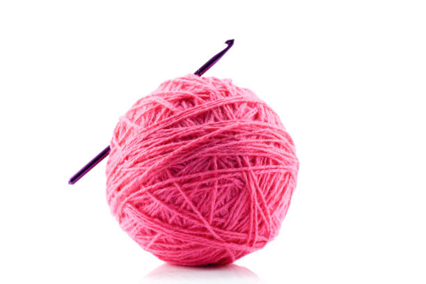 Pink yarn and crotchet hook isolated on white Pink yarn and crotchet hook isolated on white crochet photos stock pictures, royalty-free photos & images