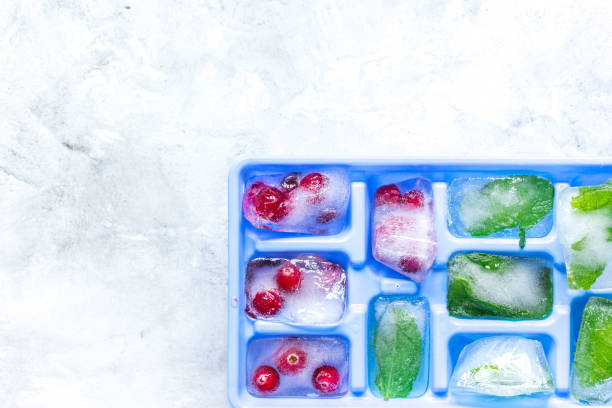 istock frozen red berries in ice cubes in tray on stone background space for text top view 681493836