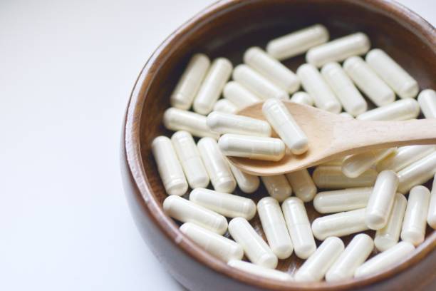 istock White supplement pills on wooden spoon 681505584
