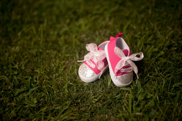 cute pink baby shoes in lush grass