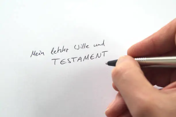 Photo of Hand writing Mein letzter Wille und Testament (German for My Last Will and Testament) in handwriting on white paper