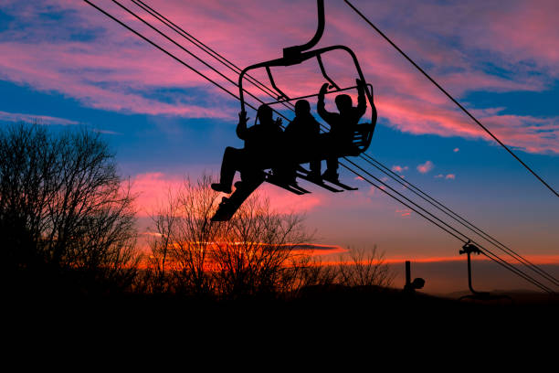 Skiers in a chairlift at the end of the day