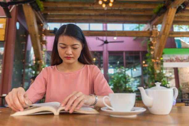 istock Asian woman enjoy her weekend, reading book and drinking hot tea 681576354