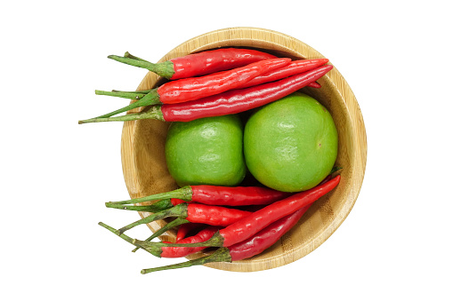 Red chili pepper and lime in wooden bowl isolated on white background with clipping path