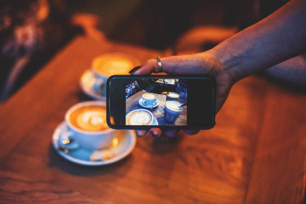istock Woman taking cell phone picture at cafe 681619856