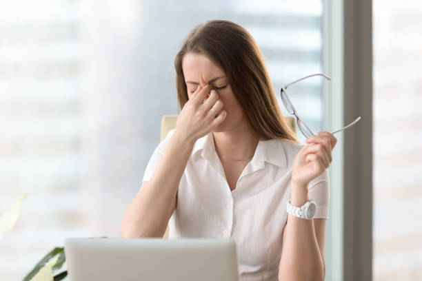 Woman feeling discomfort from long wearing glasses Tired businesswoman holding eyeglasses and massaging nose bridge. Girl feeling discomfort from long wearing glasses at workplace. Exhausted female office worker gather herself for completing work brat stock pictures, royalty-free photos & images