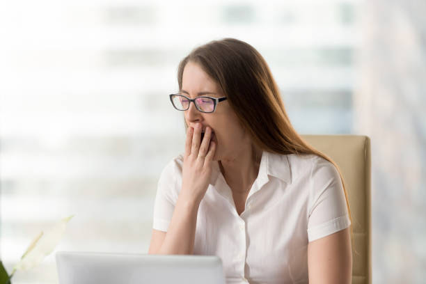 istock Sleepy girl struggles with drowsiness at work 681625402