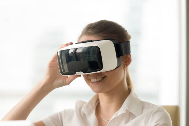istock Smiling woman looking in virtual reality glasses 681625490