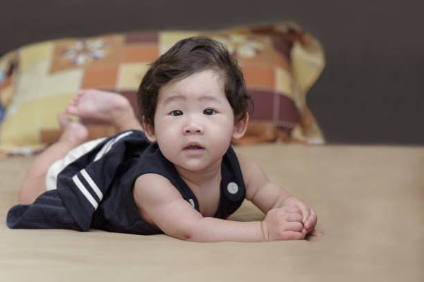 Adorable asian baby girl lying on bed. stock photo