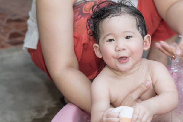 Cute asian baby girl playing sponge during bathing.
