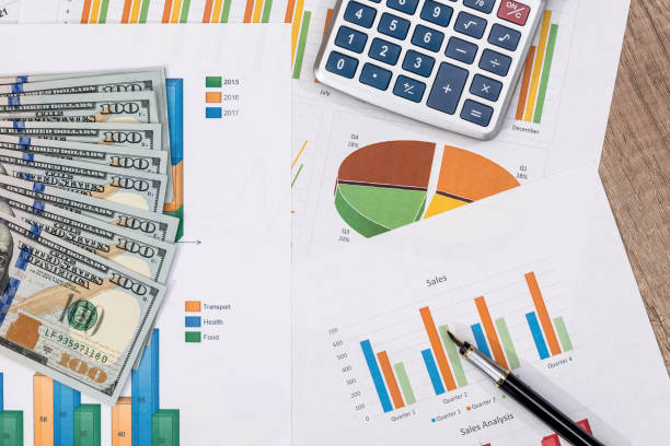 istock calculator, pen, dollar banknote above business graph. 681639096