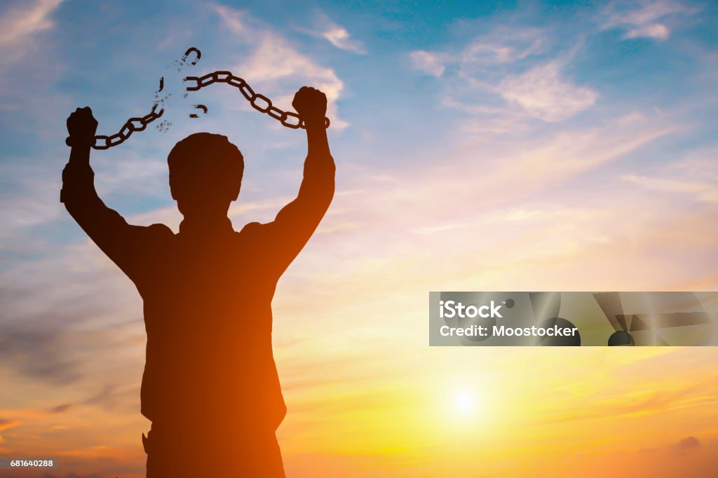 Imagem da silhueta de um homem de negócios com correntes quebradas no por do sol - Foto de stock de Liberdade royalty-free