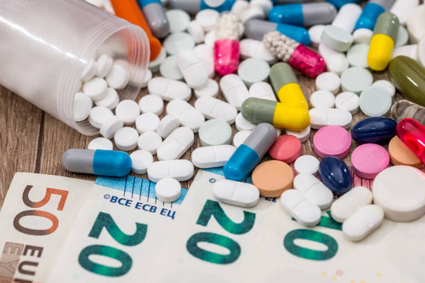 istock different pills above euros bills. close up. 681640540