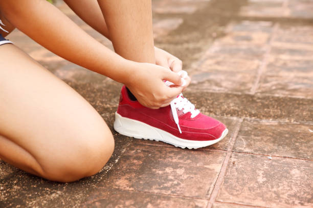 istock Asia woman runner tying shoelaces 681640624