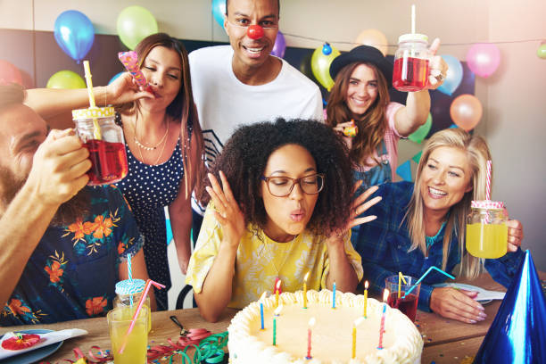 istock Woman with eyeglasses blowing on cake candles 681643624