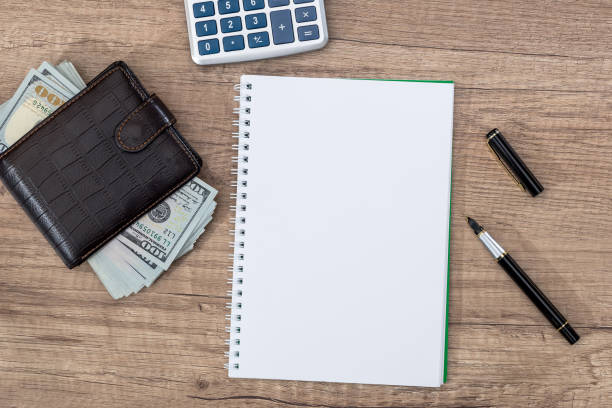istock notepad with pen, calculator, dollar bills on desk. 681643704