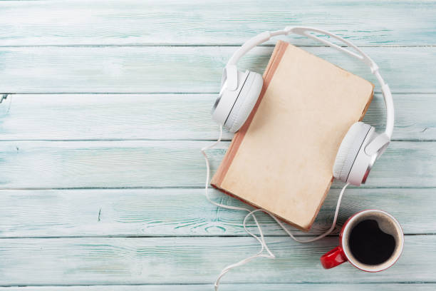 istock Audio book concept. Headphones, coffee and book 681647094