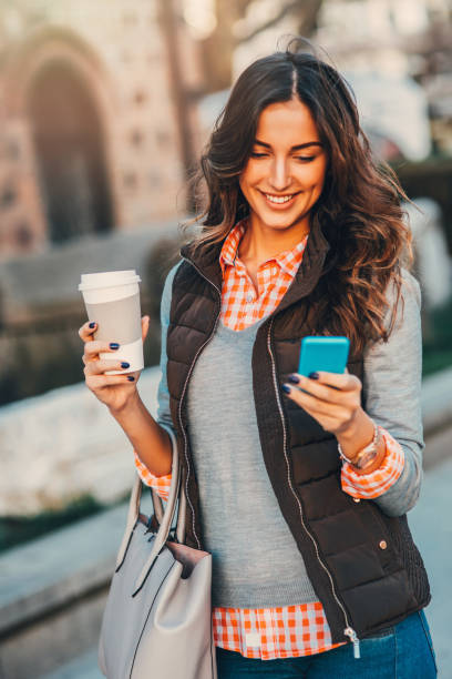 istock Woman texting and drinking coffee outdoors. 681649976