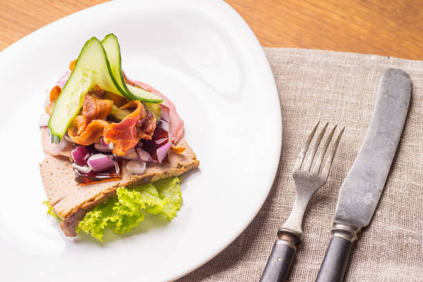 Danish specialties and national dishes, high-quality open sandwich.The very famous piece of butterbread called Veterinarian's midnight snack consisting of liverpostej, Jelly and salty beef meat, served on a plate ready for eating