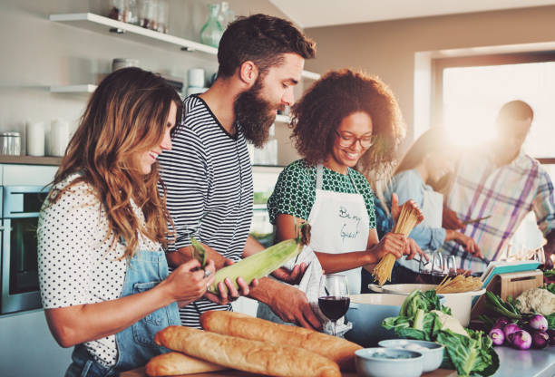 istock Friends preparing food at table in kitchen 681656938