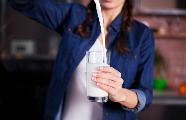 istock Female hands pour milk into a glass 681681770