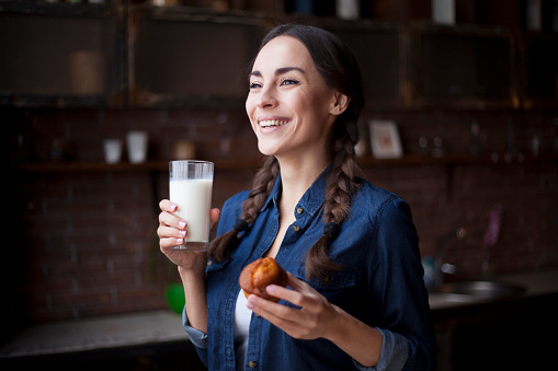 Woman with milk and cake in the kitchen