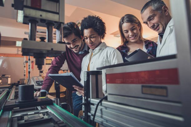 équipe d’ingénieurs heureux, analyse des données d’une machine de fabrication. - scientist research group of people analyzing photos et images de collection