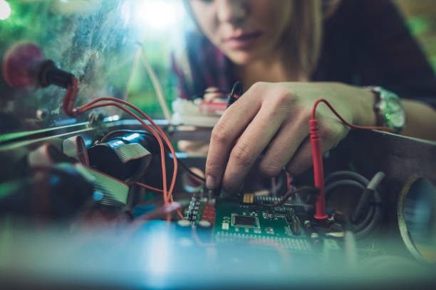 primo di una donna che ripara componente elettrico di un computer. - circuit board electrical equipment engineering technology foto e immagini stock