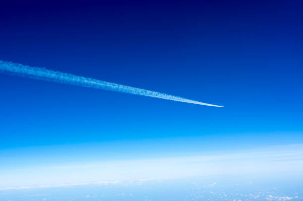 istock Airplane Leaving Contrail against dark Blue sky 681695910