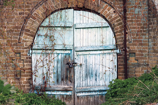 Ancient brick wall barn with rounded old wooden door