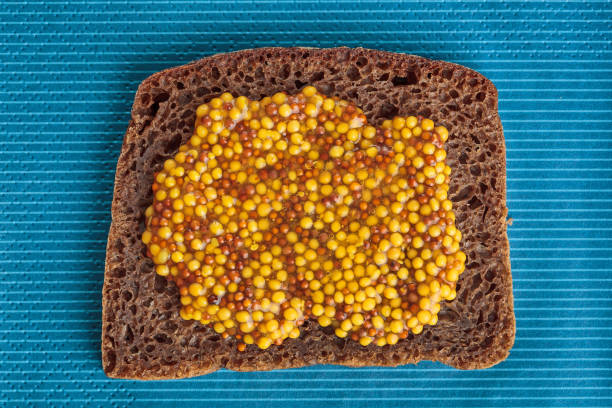 Slice of rye bread with wholegrain mustard stock photo
