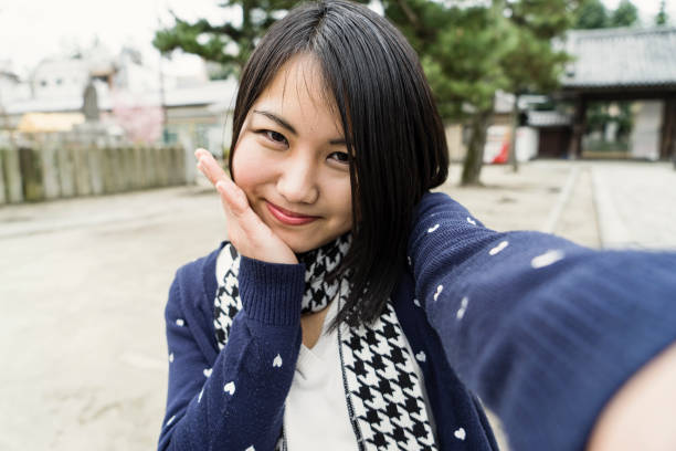 istock Young woman shooting Selphy with a smartphone 681722320