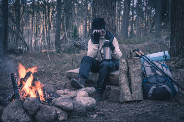 istock A woman resting by the campfire and drinking a hot drink 681729850