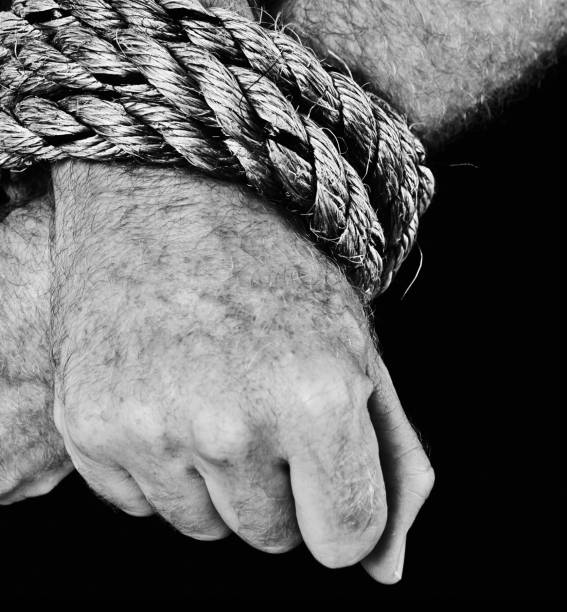 istock Masculine hands tied with heavy rope. Black and white. 681729902