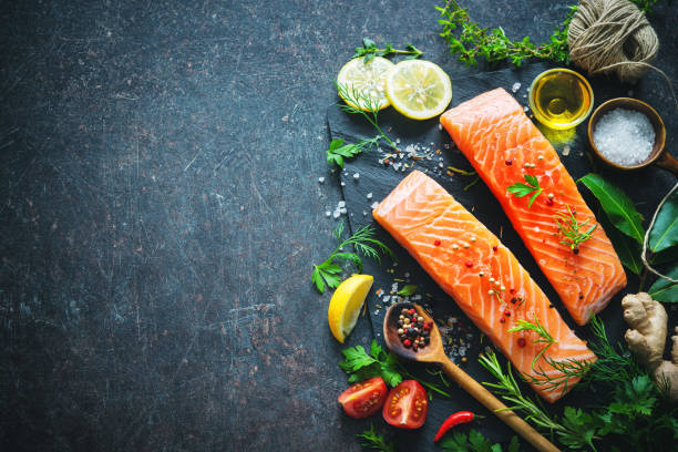Fresh salmon fillet with aromatic herbs, spices and vegetables Fresh salmon fillet with aromatic herbs, spices and vegetables. Balanced diet or cooking concept serving size photos stock pictures, royalty-free photos & images