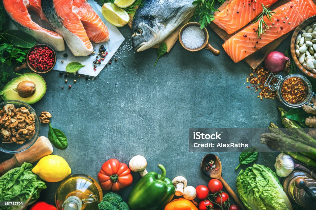 Assortment of fresh fish with aromatic herbs, spices and vegetables Assortment of fresh fish with aromatic herbs, spices and vegetables. Balanced diet or cooking concept Fish Stock Photo