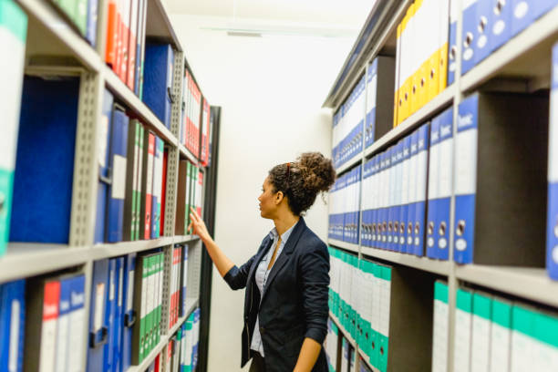 mujer secretaria en archivo del sótano - fichero archivador fotografías e imágenes de stock