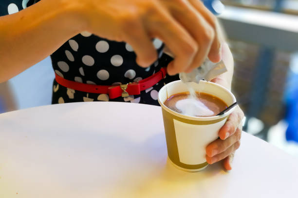 istock Hand pouring unhealthy non dairy creamer from sachet into coffee 681745142