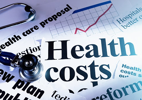 Newspaper headlines concerning health costs with a doctor's stethoscope.