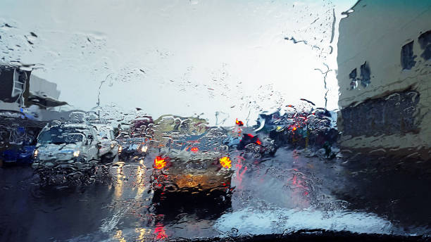 regnerischen tag verkehr gesehen durch nassen windschutzscheibe - sintflutartiger regen stock-fotos und bilder
