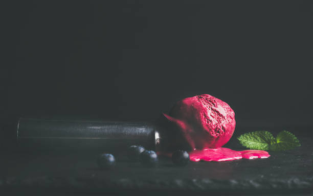 istock Melting blueberry ice-cream scoop over black background, copy space 681758226
