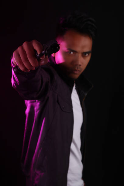 istock Handsome asian man holding a gun 681758460